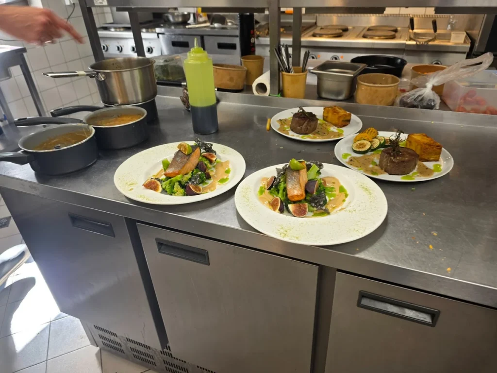 Przygotowywanie i wydawanie dań w kuchni restauracji Le Vert